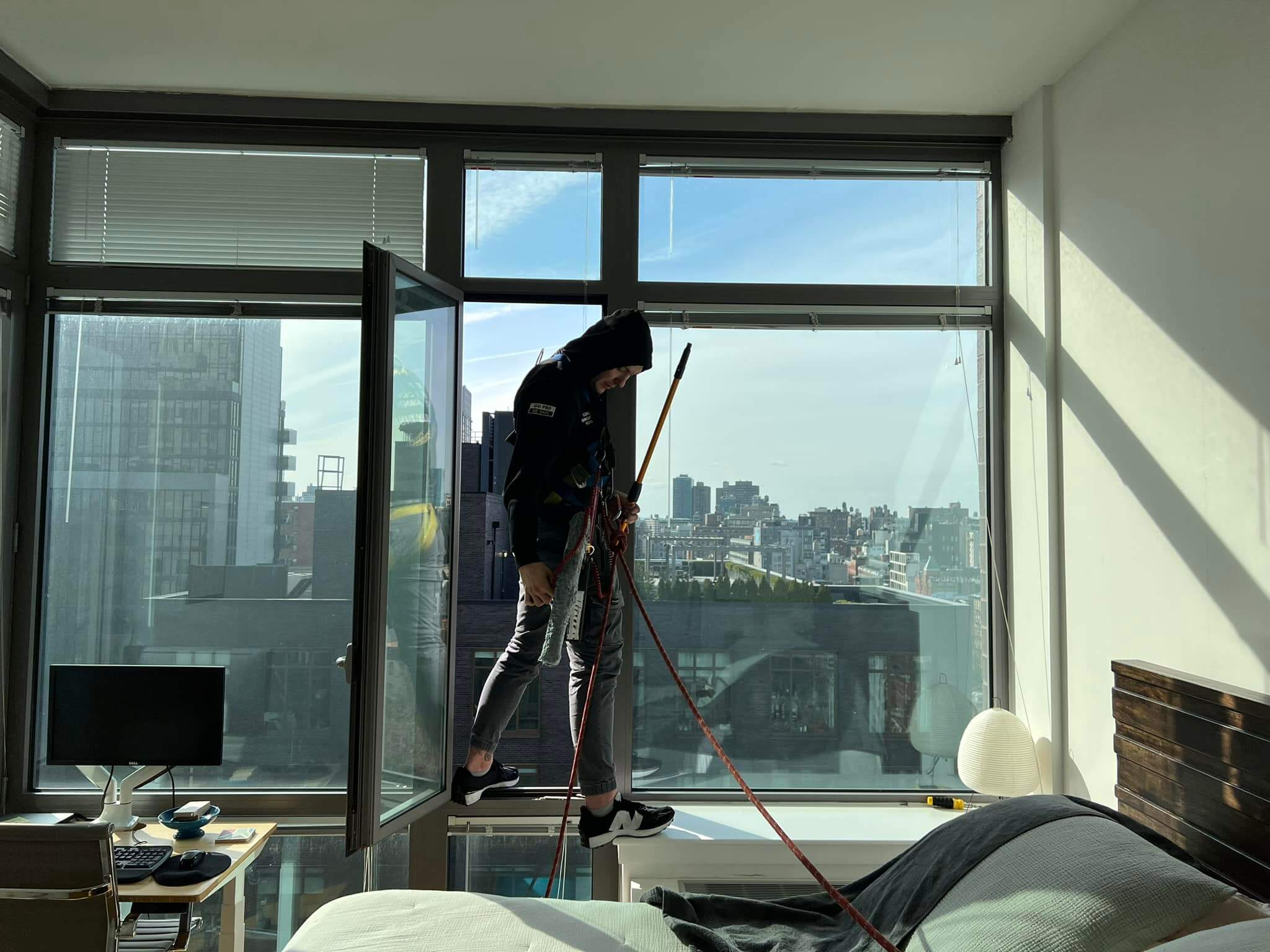 Technician in harness cleaning windows of a NYC apartment